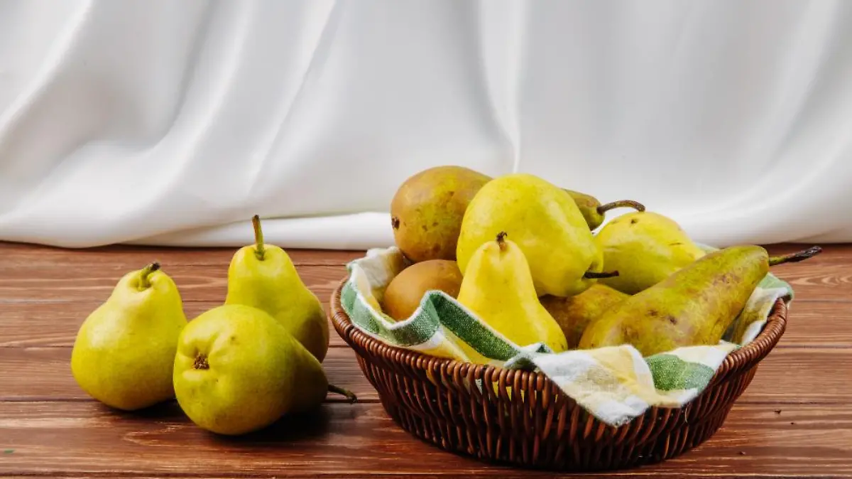 vista lateral peras maduras frescas cesta mimbre sobre fondo madera 1