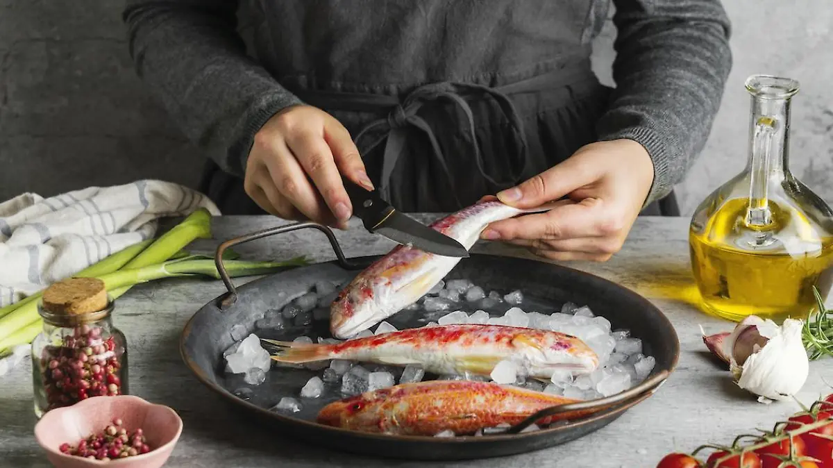 mujer preparando pescado cocinar