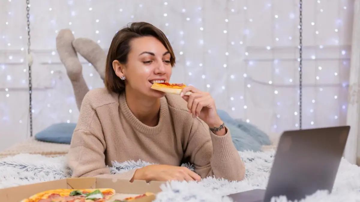 mujer comida rapida al entrega cama dormitorio casa mujer sola disfrutando comida grasa pizza