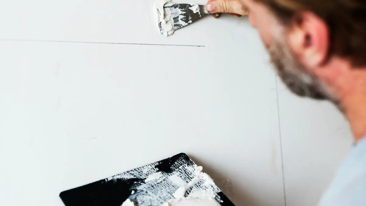 trabajador construccion pintando pared