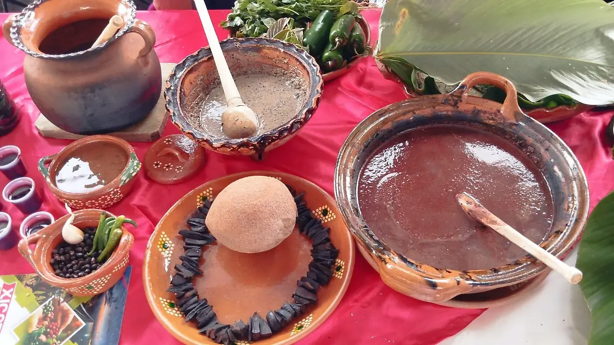 en el mocajete la salsa macha con hormigas y en la cazuela el molito de pixtli