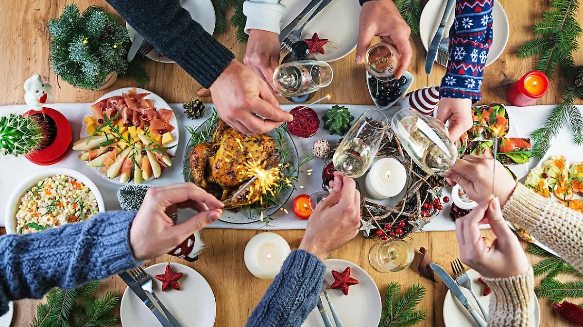 Baked turkey. Christmas dinner. The Christmas table is served with a turkey, decorated with bright tinsel and candles. Fried chicken, table.  Family dinner. Top view, hands in the frame