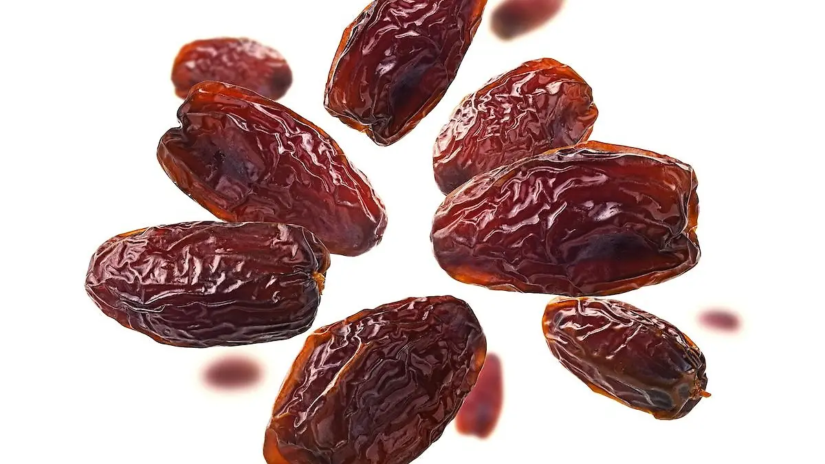 Dried dates levitate on a white background