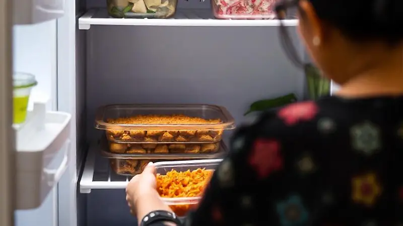 pikaso texttoimage A Mexican woman from behind placing tupperware wit