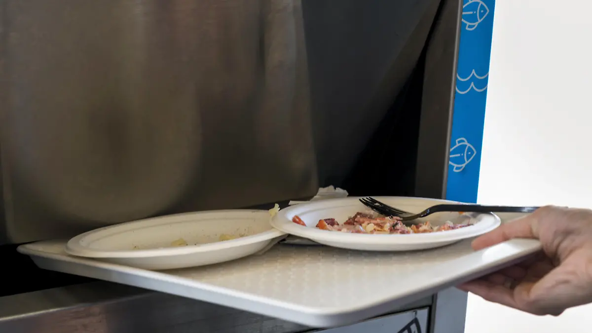 close up individual throwing away food leftovers