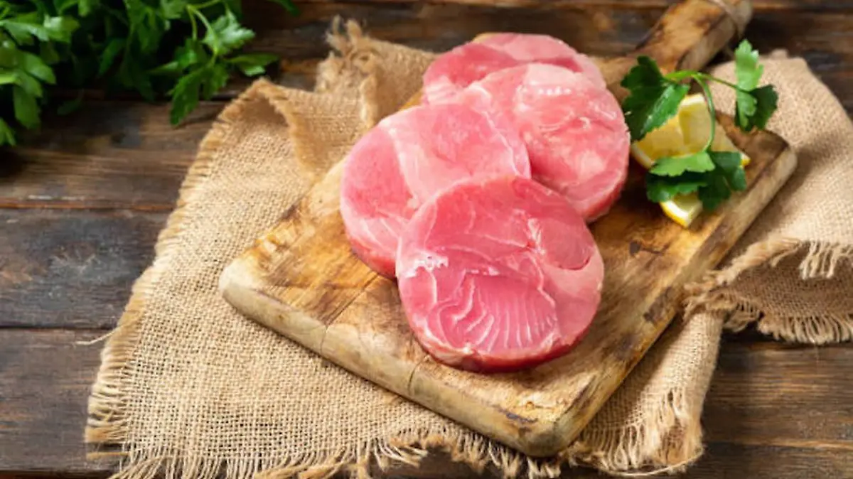 Tuna medallions on a wooden Board on a brown wooden table