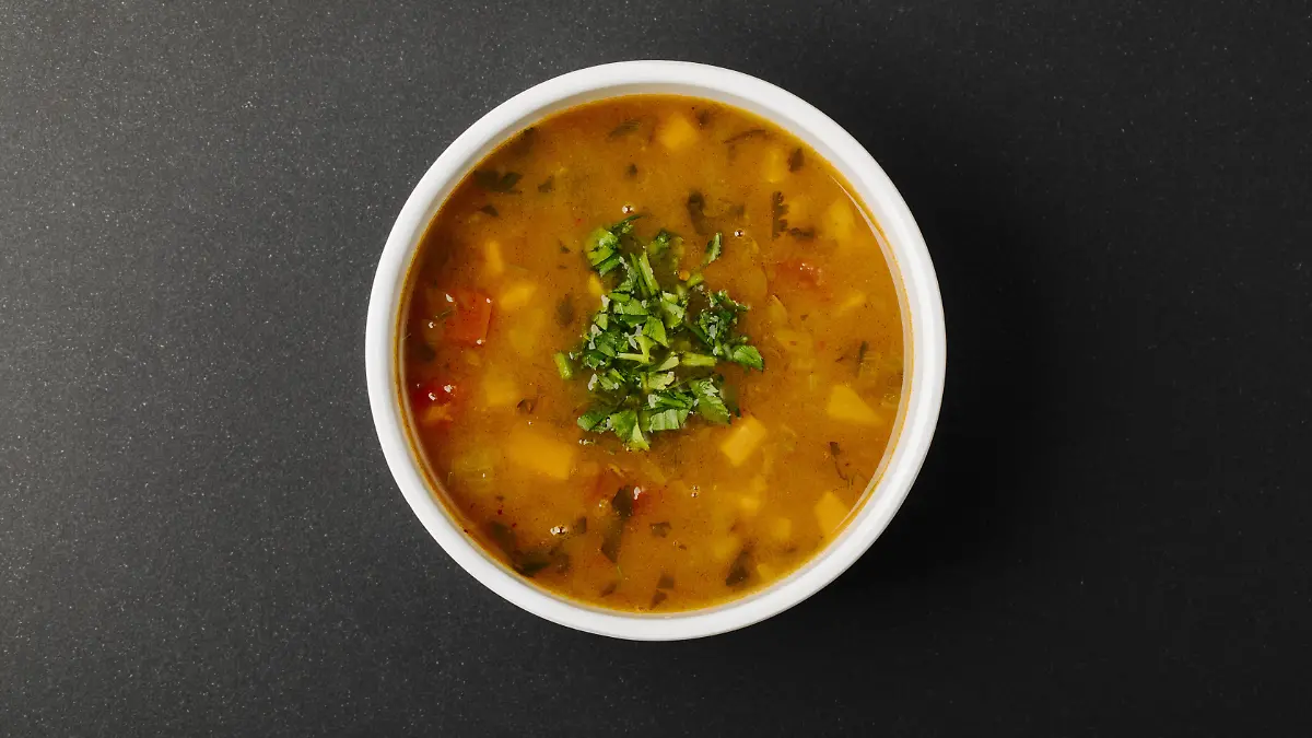 lentil soup with mixed ingredients herbs white bowl