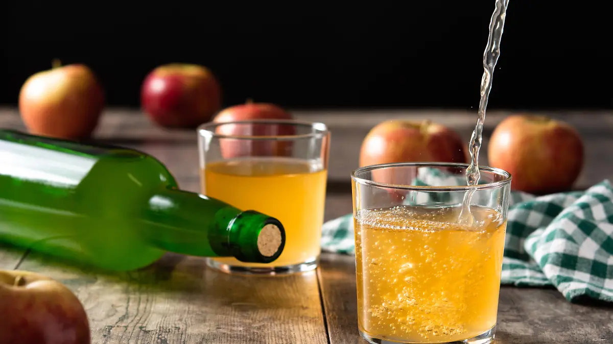 Pouring apple cider drink into a glass