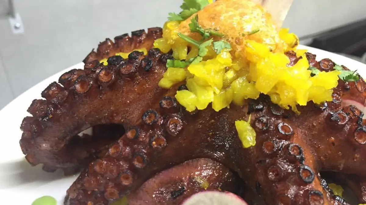 Pulpo adobado con chile de la tierra y flameado con sotol chutney de piña con cúrcuma