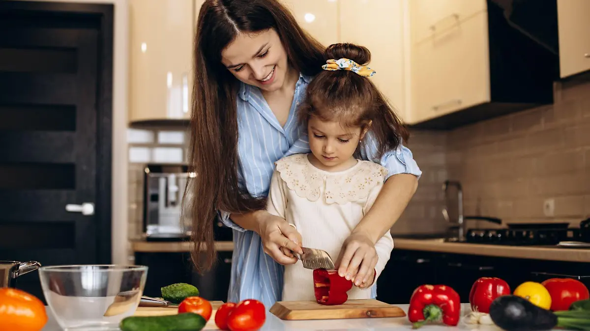 mother with daughter preparing salad from fresh vegetables at the kitchen 123