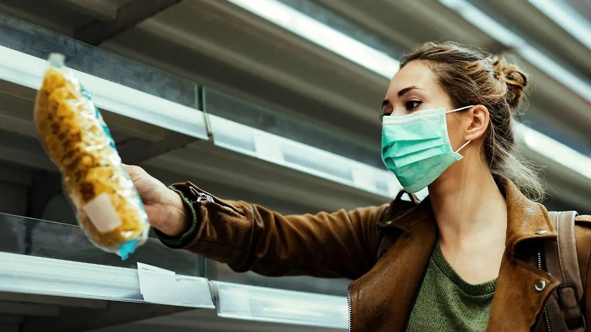 young woman buying groceries while wearing protective face mask in the supermarket during covid19 pandemic 123
