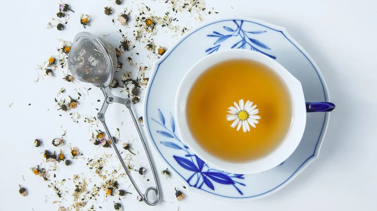 Top view a cup of chamomile with herbs on white background