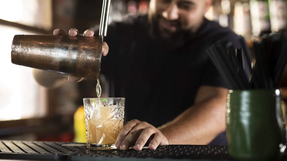 close-up-bartender-creating-delicious-drink