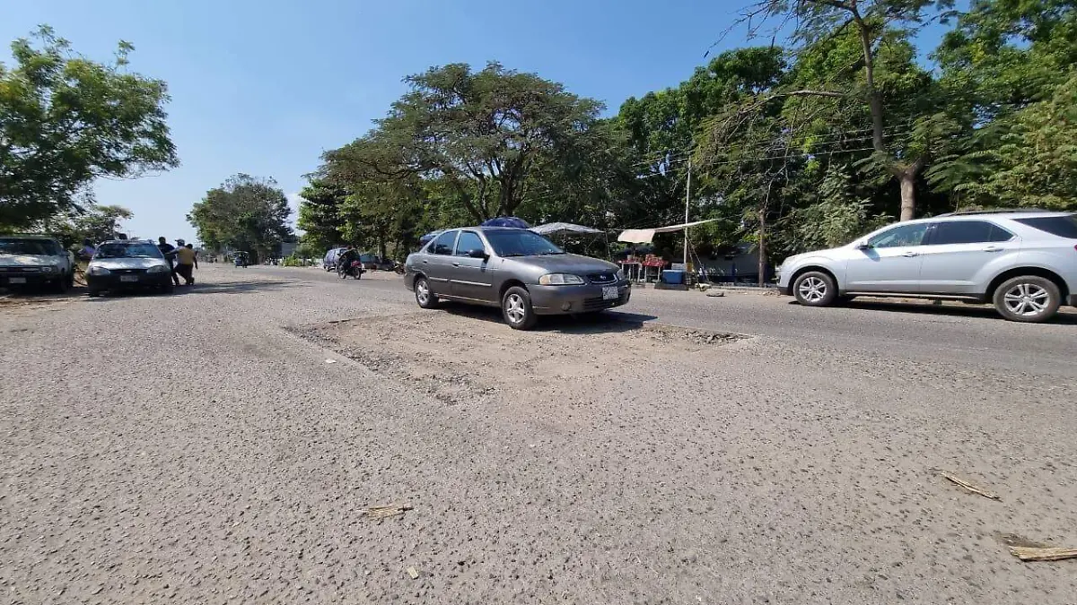 autos transitando sobre baches