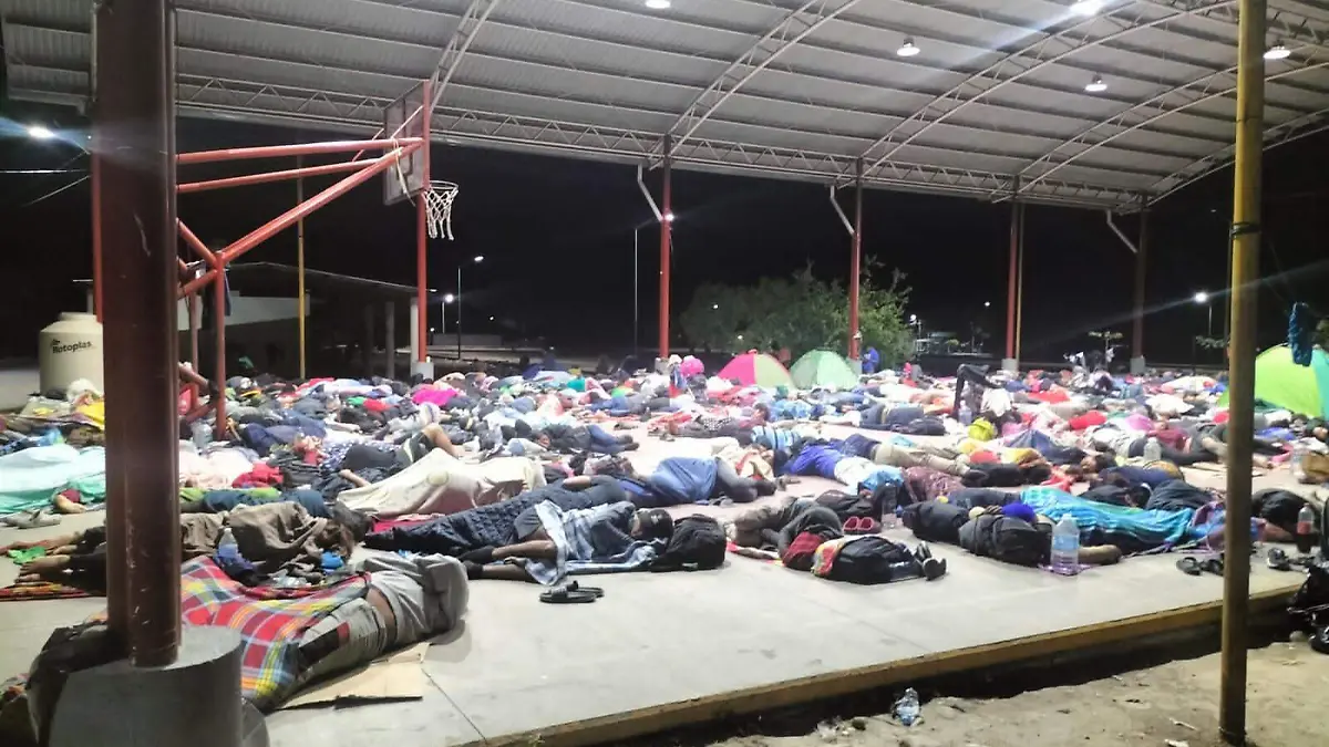 migrantes durmiendo en una cancha