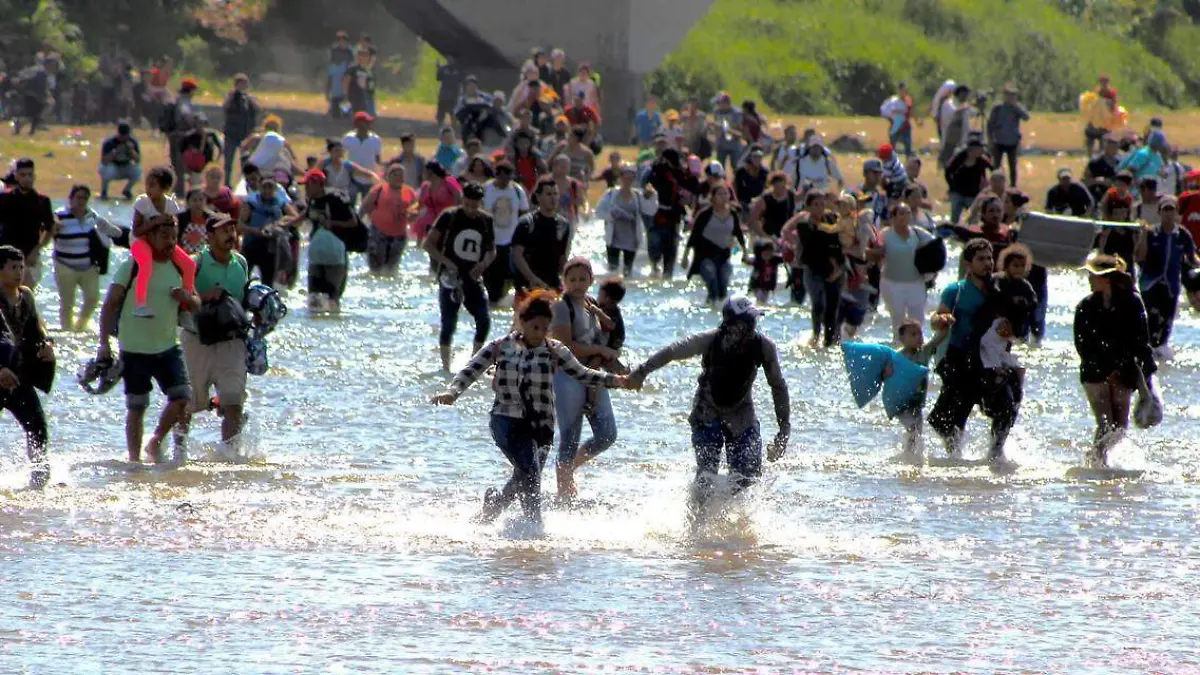 Migrantes cruzando el río
