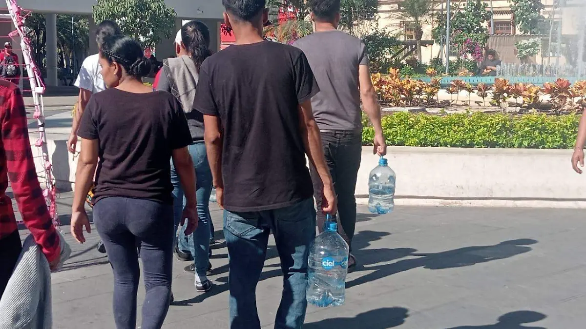 personas cargando agua