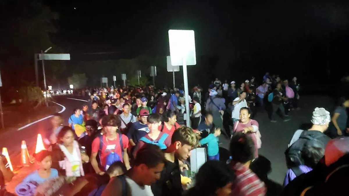 Migrantes caminando por la carretera costera