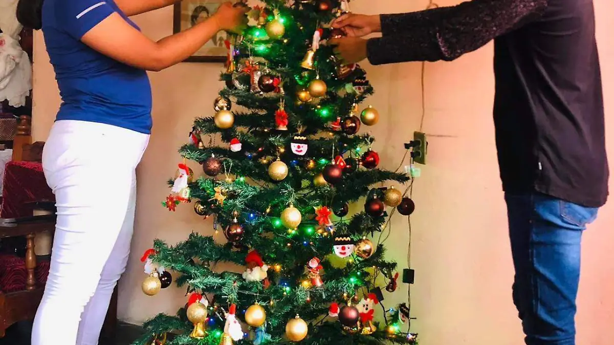familia adornando árbol de navidad 