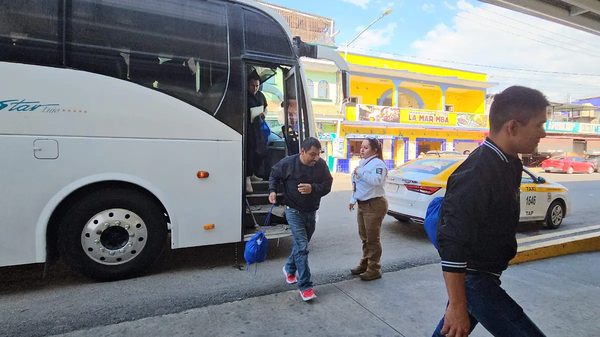 Migrante bajando del autobús en terminal