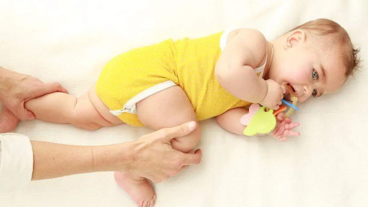 4.tumbado sobre su lado izquierdo, estira una de sus piernecitas y dobla la otra, presionando con su muslo el abdomen. Repite con la otra pierna.