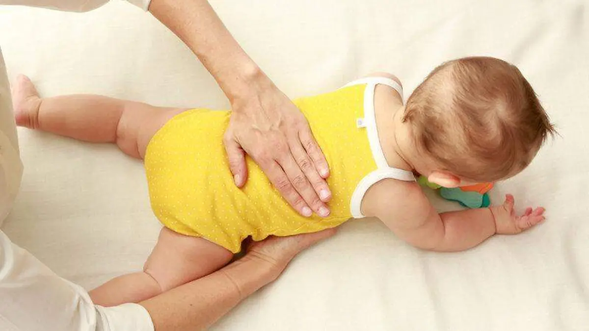 2. Ponlo boca abajo y pon una de tus manos bajo su estómago y otra sobre su espalda y presiona ambas.