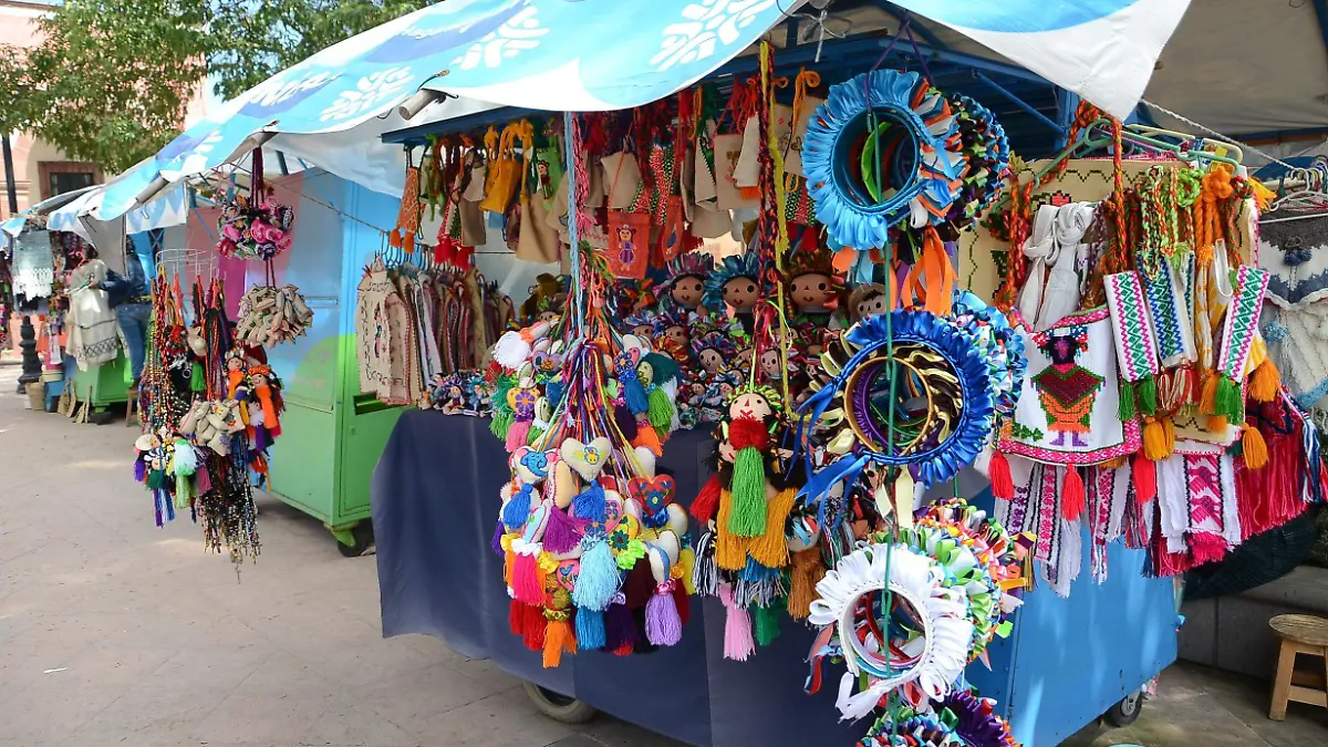 En su carrito multicolores vende toda clase textiles que reflejan su cultura.