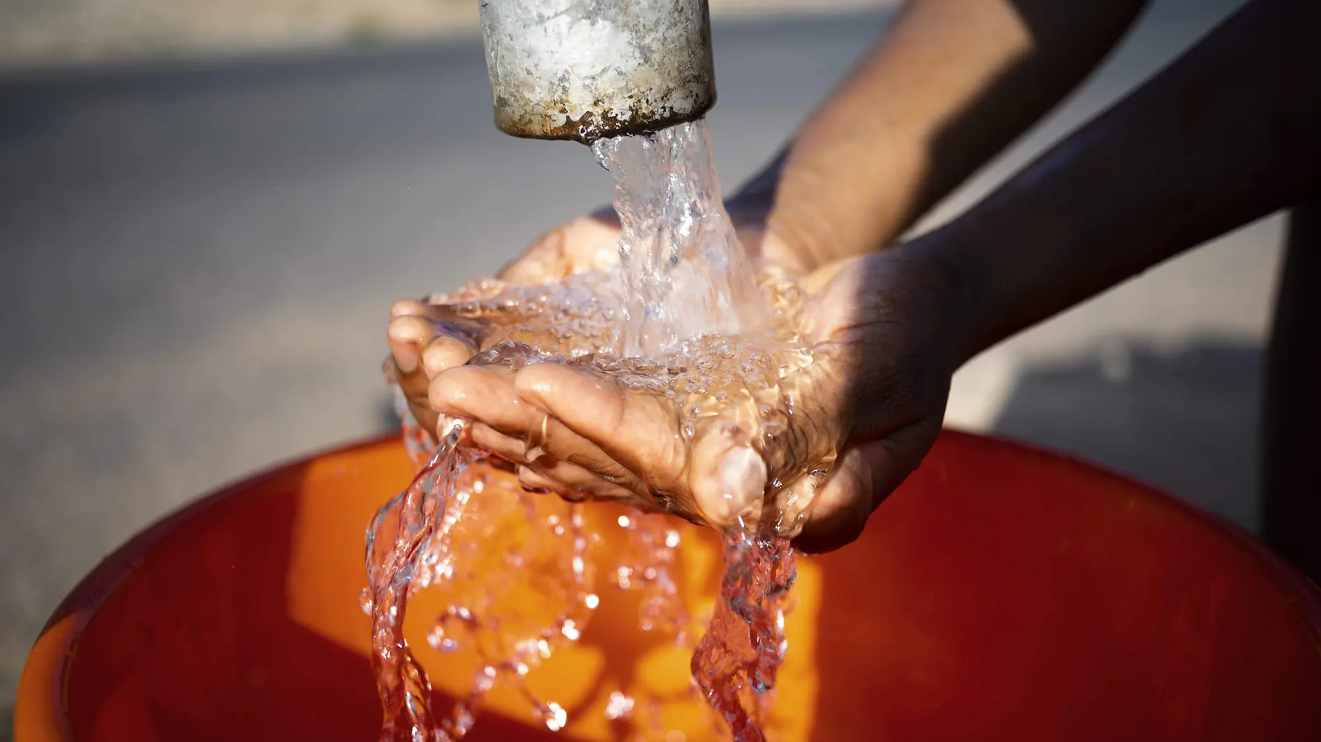 mujer-africana-vertiendo-agua-recipiente-al-aire-libre