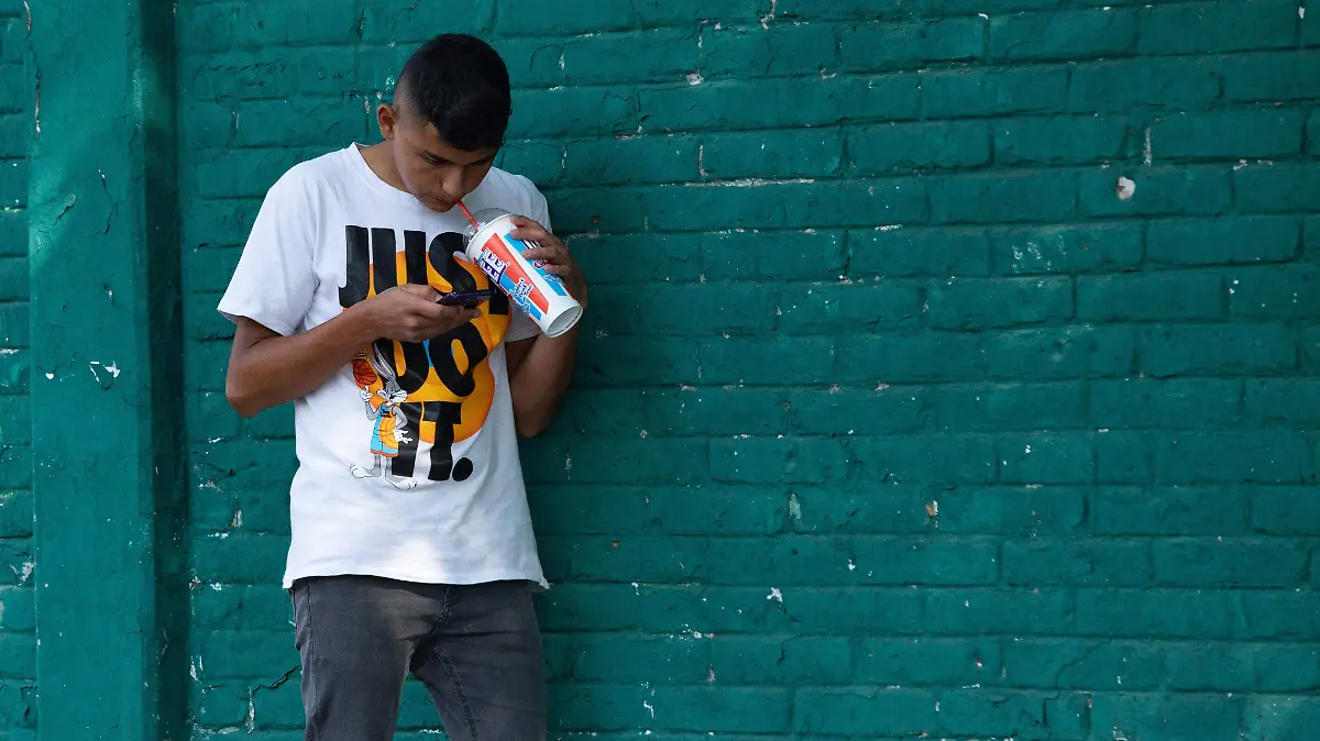 Joven con celular en la mano