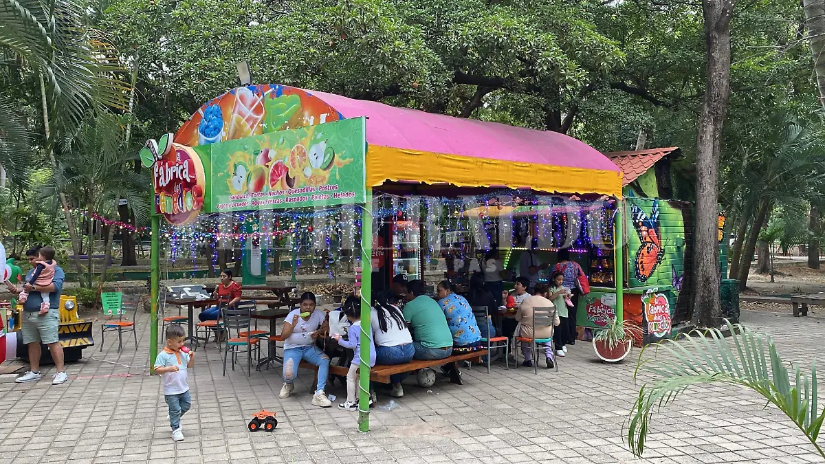 Personas comiendo en local dentro de parque