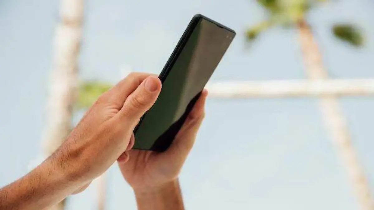 close-up-manos-sosteniendo-telefono-negro_23-2148264043