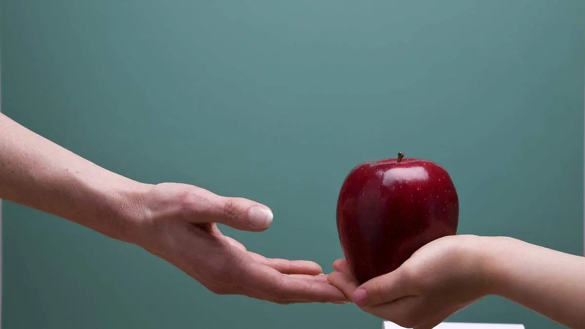 un-alumno-regalando-una-manzana-a-una-maestra