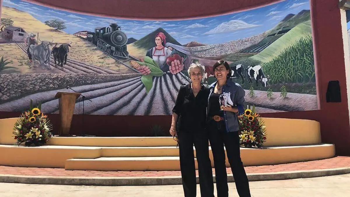 FOTO CORTESÍA Libertad Villarreal y Ariadne Lozano, junto al mural del ejido Cuauhtémoc, del que forman parte