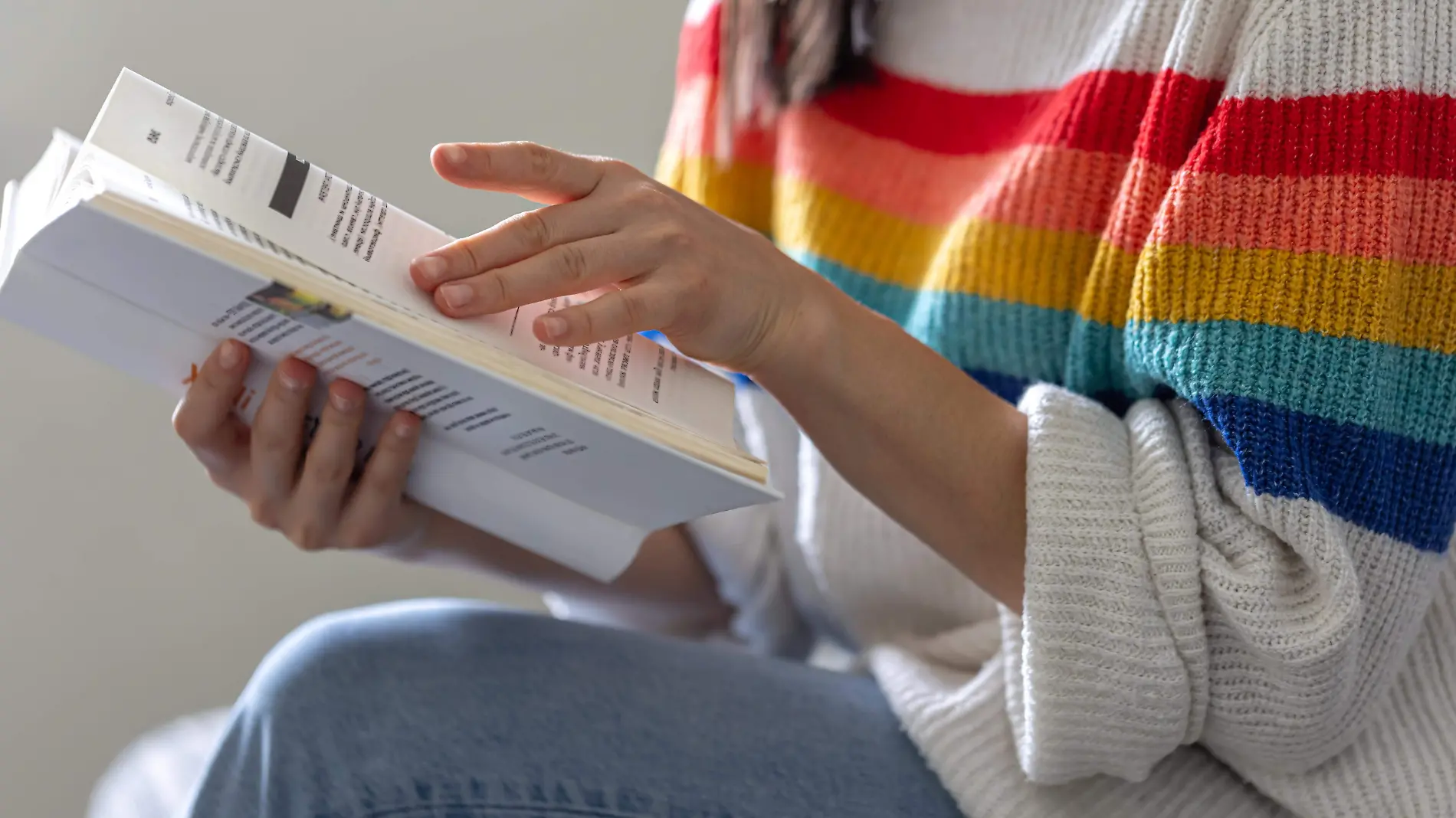 close-up-open-book-hands-girl-bright-colored-sweater