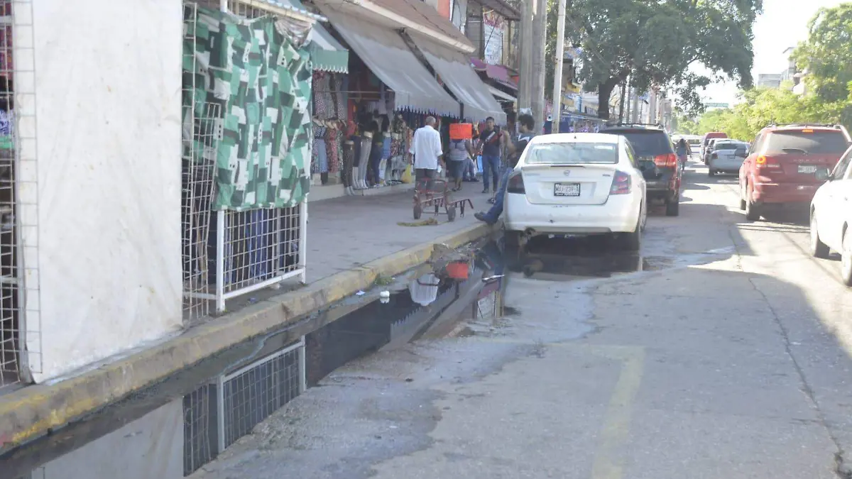 Sortean los charcos de agua negra para poder comprar en el centro de Villahermosa