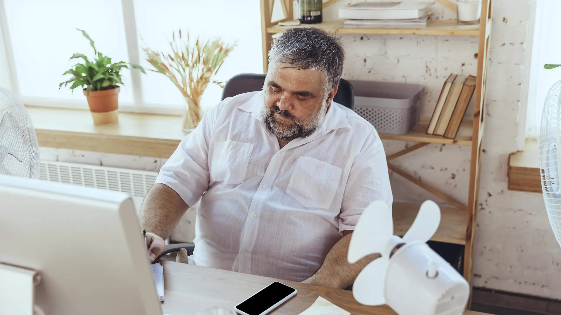 businessman-in-office-with-computer-and-fan-cooling-off-feeling-hot-flushed