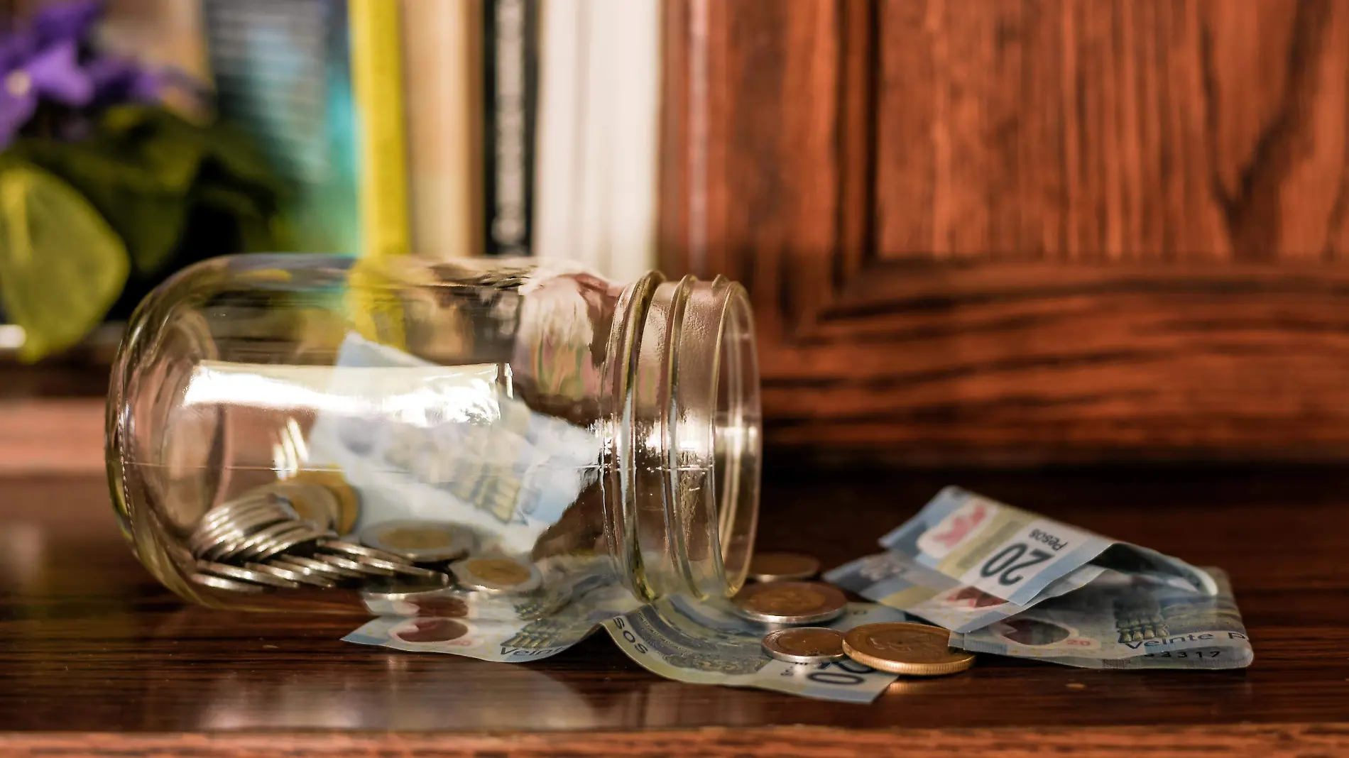 closeup-of-coins-in-jar-on-the-table-with-pesos-under-the-lights