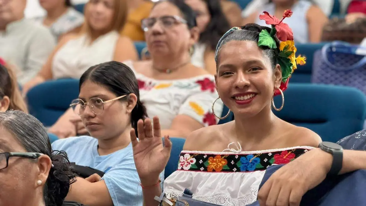 Una de las asistentes al Foro de Tira Bordada se da tiempo para saludar y sonreir