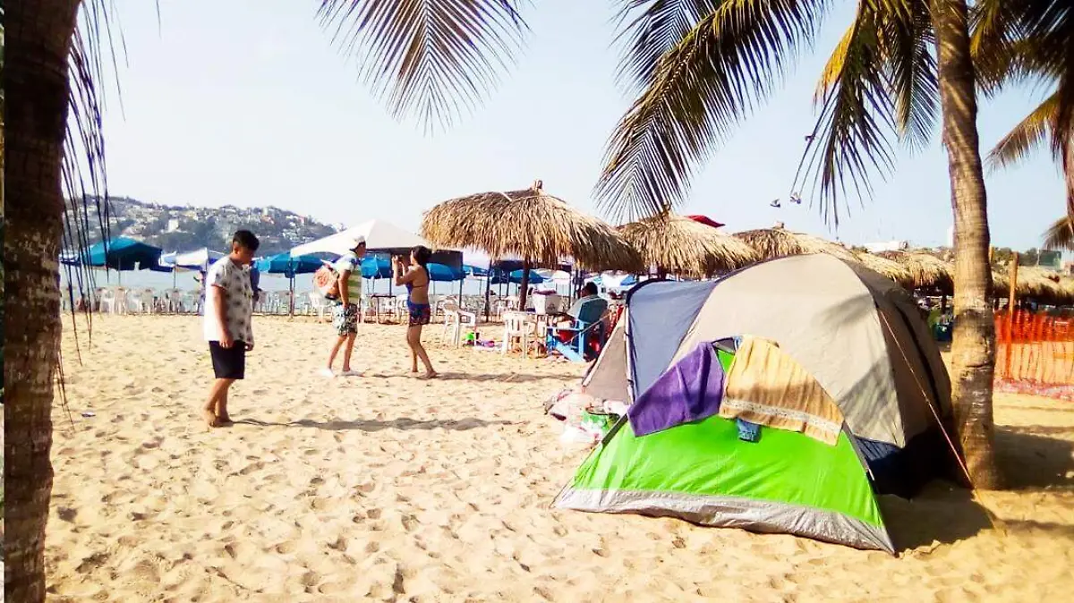 turistas duermen en la playa