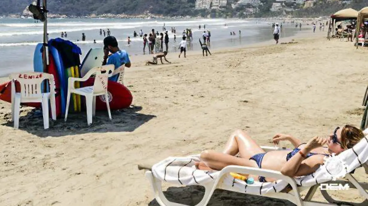 Acapulco- turista tomando sol en playa revolcadero