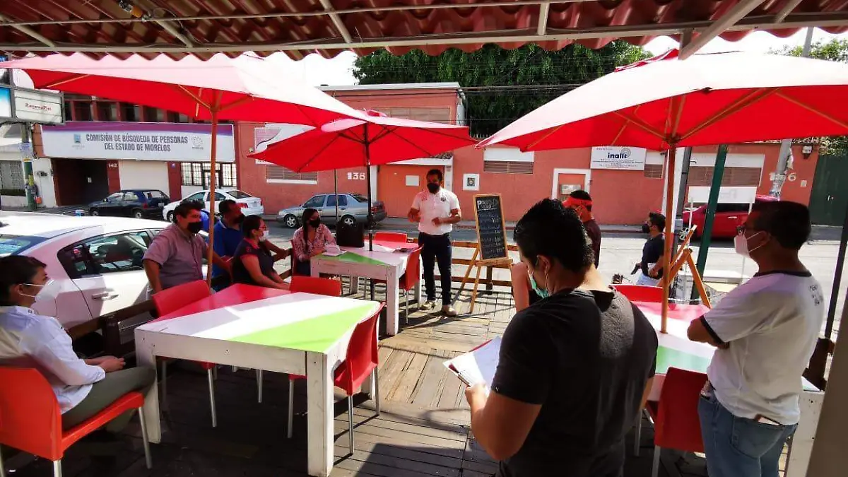 En un negocio de comida, elementos policiacos llevan a cabo una reunión sobre los Comités Vecinales