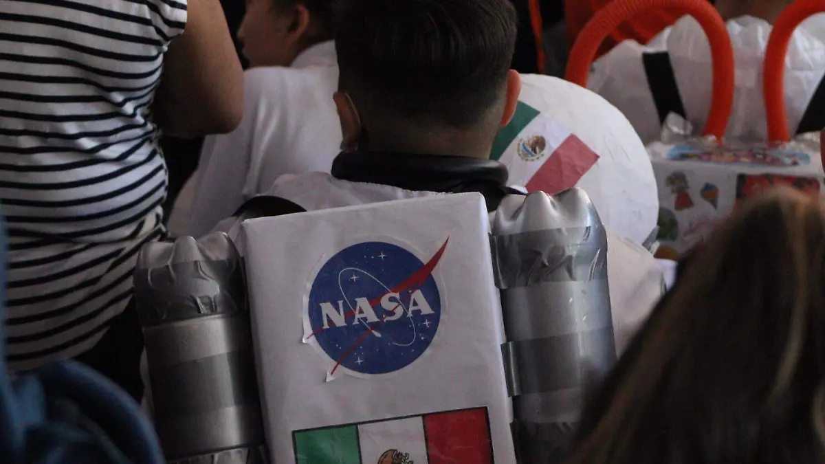 Un niño con un disfraz de cohete espacial a la conferencia de Katya Echazarreta