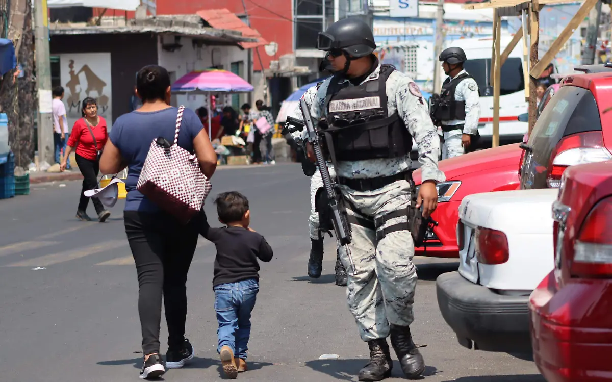 seguridad-madre-e-hijo-pasan-a-lado-de-un-elemnto-de-la-guardia-nacional