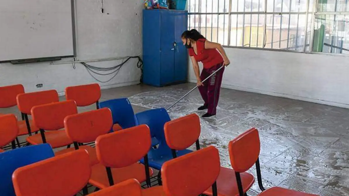 Mujer limpiando un salón de clases