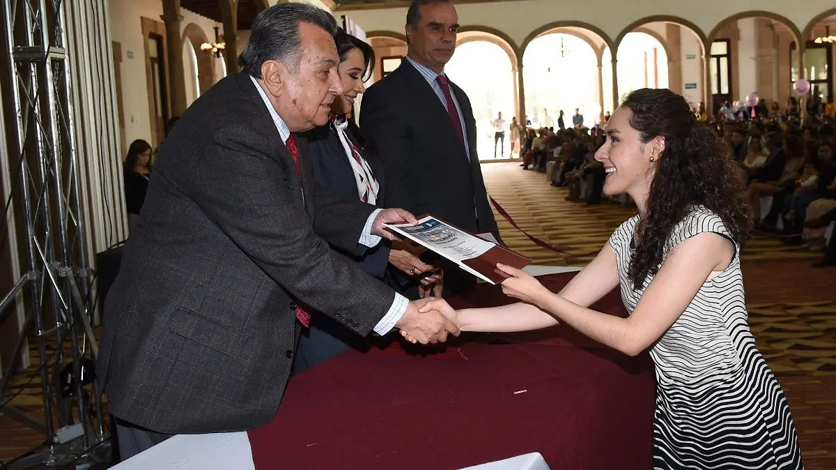 Rubén Calderón Luján titular de la SEED al momento de entregar una constancia a la joven profesionista