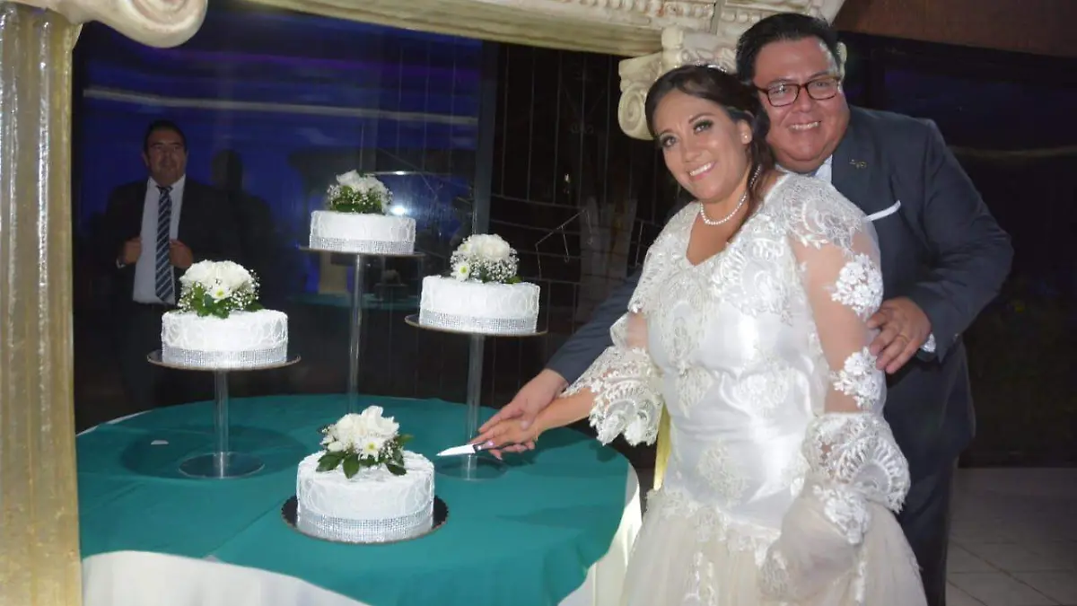 La feliz pareja al momento de partir su pastel de bodas
