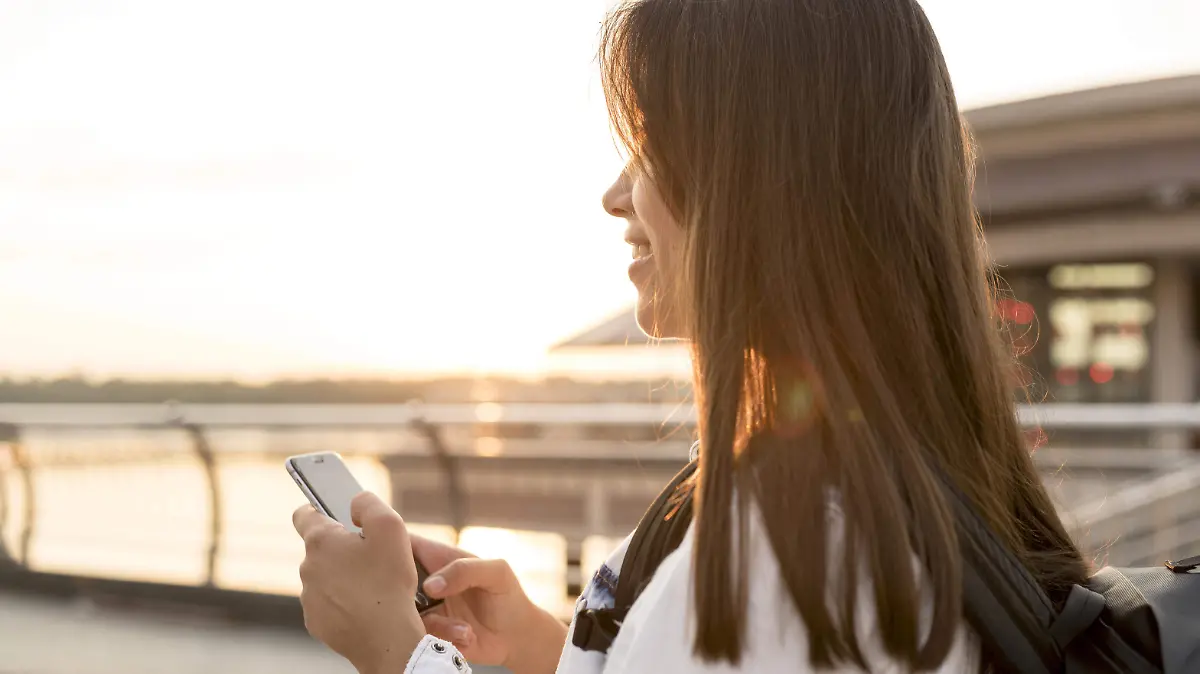 side-view-smiley-woman-using-smartphone-while-traveling-alone