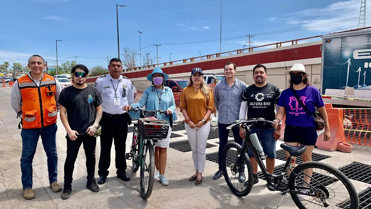 Ciclistas reunidos en parrilla pluvial con autoridades