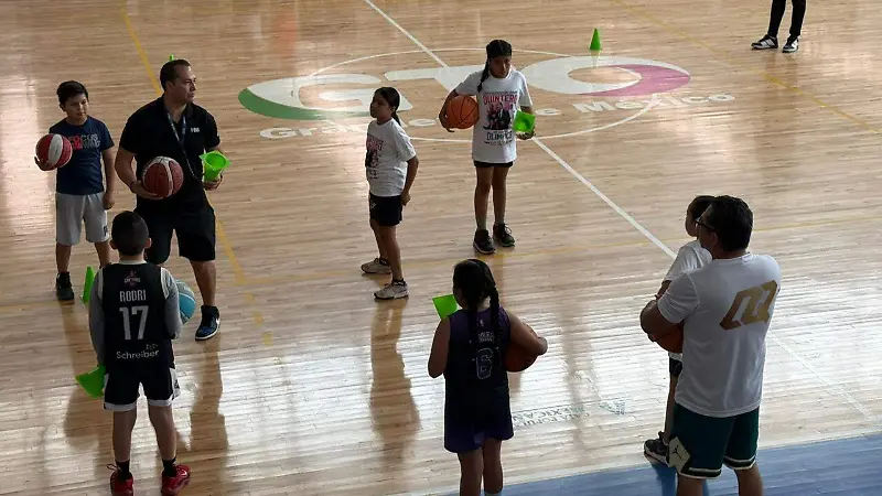 Omar Quintero guiando a los jòvenes en campamento de basquet