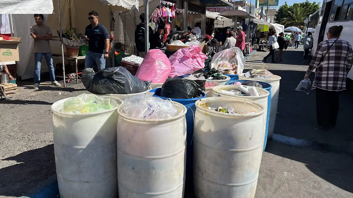 En la parada de autobuses se encuentran los tambos de basura en la espera del servicio recolector 
